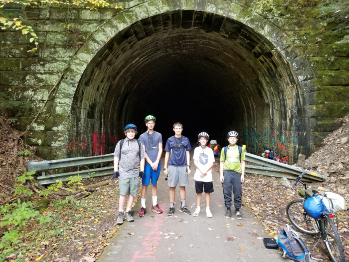 Scouts in front of a tunnel on rails to trails